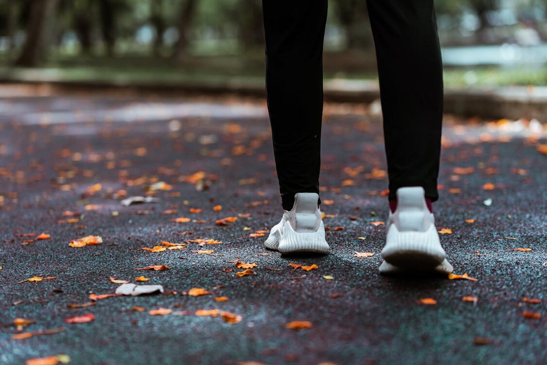 Person in tennis shoes walking through nature trail